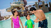 A family having fun at pool with waterslides at Castaway Cay