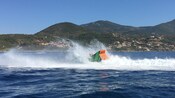 Una lancha a motor llena de pasajeros chapotea en el agua