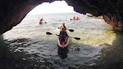 Kayakers entering a coastal cave