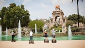 Quatro hóspedes em Segways, fazendo uma parada em uma fonte ativa