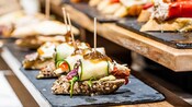 An appetizer consisting of bread topped with meat, vegetables and sauce