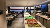 Tres visitantes hacen pedidos en un bar de ostras con vistas al mar