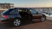 A late model sedan parked next to a lighthouse
