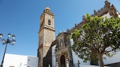 A gothic cathedral that has a tall bell tower with a dome and spire