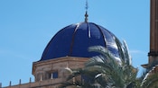A tiled dome set amid date palm trees