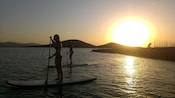 2 mulheres em pranchas de stand up paddle na água