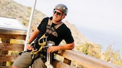 A man wearing a helmet and zip lining gear