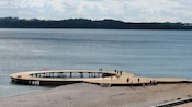 Personas que caminan alrededor de un muelle circular sobre el agua