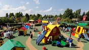 Children in a play area with Lego playhouses and slides