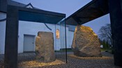Dos rocas talladas grandes, cada una dentro de una caja de vidrio