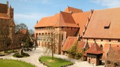 The courtyard of a large brick castle complex