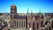 A large, multistory brick church with a bell tower and several steeples