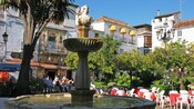 Uma fonte em uma praça da cidade repleta de cafés movimentados