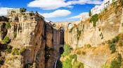 Uma ponte e um antigo aqueduto entre duas massas rochosas e uma cachoeira