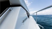 The handrails and side deck of a pleasure boat sailing out to sea