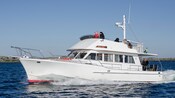 Passengers relaxing and enjoying the ocean views from the top tier of a tour boat 