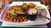 Un plato con comida de bar frita servida con garbanzos al estilo indio