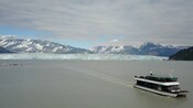 A double deck catamaran sailing away from a glacier