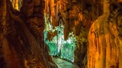 A walking path with a railing, inside of the Drogarati Cave