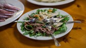 An anchovy salad on a plate with 3 forks