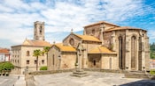 A stone bell tower and church complex built in the Romanesque style