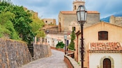 A historical Italian village with stone paths, red tile roofs, old churches and cast iron street lamps