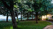 A coastal hilltop with lush trees and a rustic building with a dining area