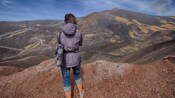 A Guest looking out to a scorched valley while standing within a volcanic landscape