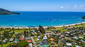 A tropical coastline featuring a beach and low slung buildings
