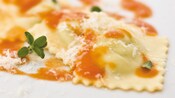 Ravioli drizzled in marinara sauce and topped with parmesan