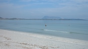 A sandy beach with mountains in the distance