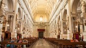 The interior of a domed church with multiple sculptures, frescos and ornate decorations