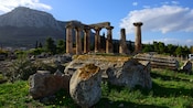 The columned ruins of an ancient temple near a mountain