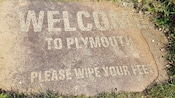 Una placa de piedra que dice Welcome to Plymouth Please Wipe Your Feet (Bienvenido a Plymouth, limpia tus pies)