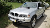 A BMW SUV parked near hydrangea bushes
