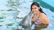 A dolphin kissing a woman on the cheek