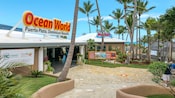 A recreation area featuring palm trees and a building with a sign that reads Ocean World Puerto Plata, Dominican Republic