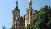 Um castelo com 2 torres sineiras e um campanário