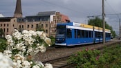 A commuter train traveling through a historical town