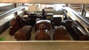 A tray of chocolate confections shaped like trains, motorcycles and cars