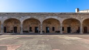 A courtyard and arched promenade inside the historic stone fort of San Cristobal