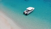 A modern touring boat docked next to shore