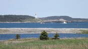 A lighthouse on the edge of a rocky shoreline 