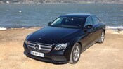 A late model Mercedes Benz sedan parked next to the ocean