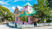 A Victorian beach cottage surrounded by a picket fence