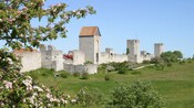 The stone ruins of a medieval fortification wall featuring towers and turrets