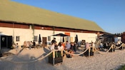 An outdoor dining area with people sitting at picnic tables