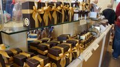 A shelf in a gift shop lined with gift boxes filled with chocolate