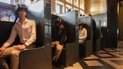 Visitantes usando equipamentos de realidade virtual sentados em cabines