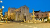 Una fuente junto a una catedral de piedra medieval 